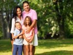 happy family of four posing outside