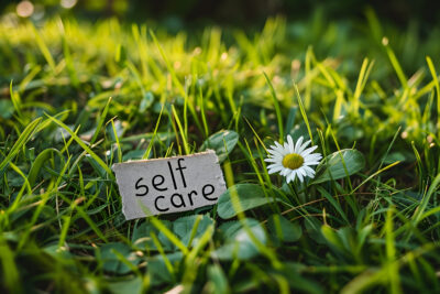 self care day note on a green meadow