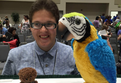 A young lady smiles with two stuffed animals in front of her